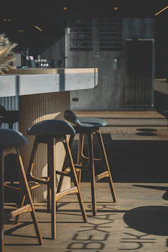 Modern restaurant bar with personalized stools and ambient lighting.