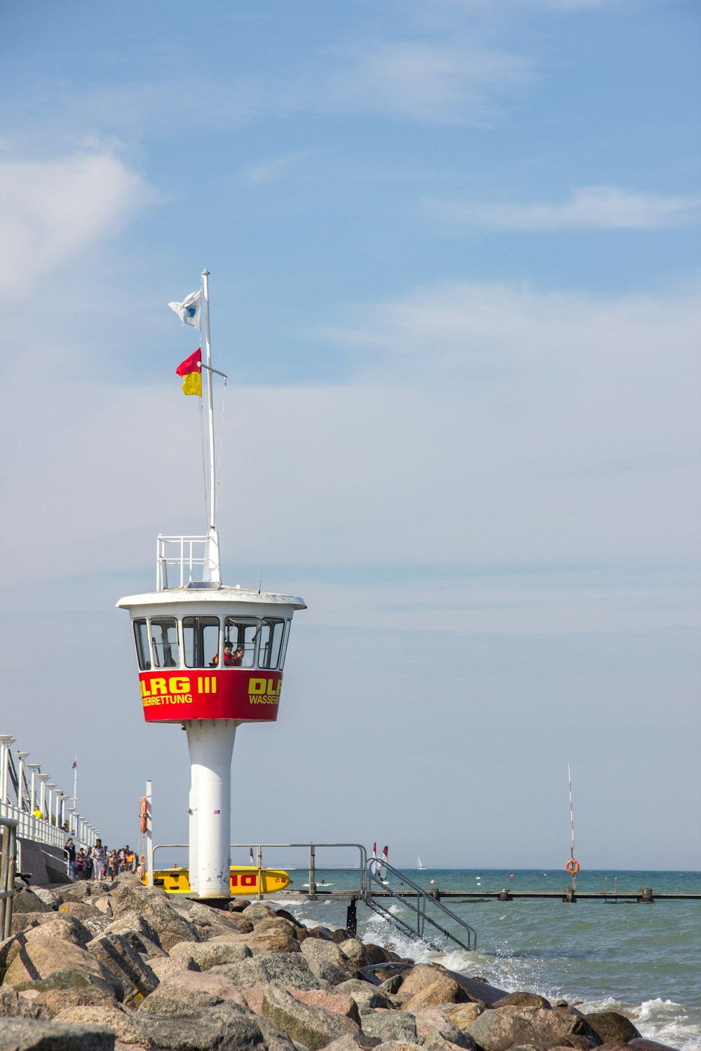 white and red flag on top of white and red tower