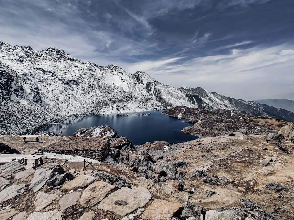 lake in the middle of rocky mountains under blue sky during daytime