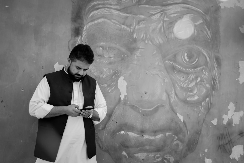 man in white vest and black vest standing beside wall