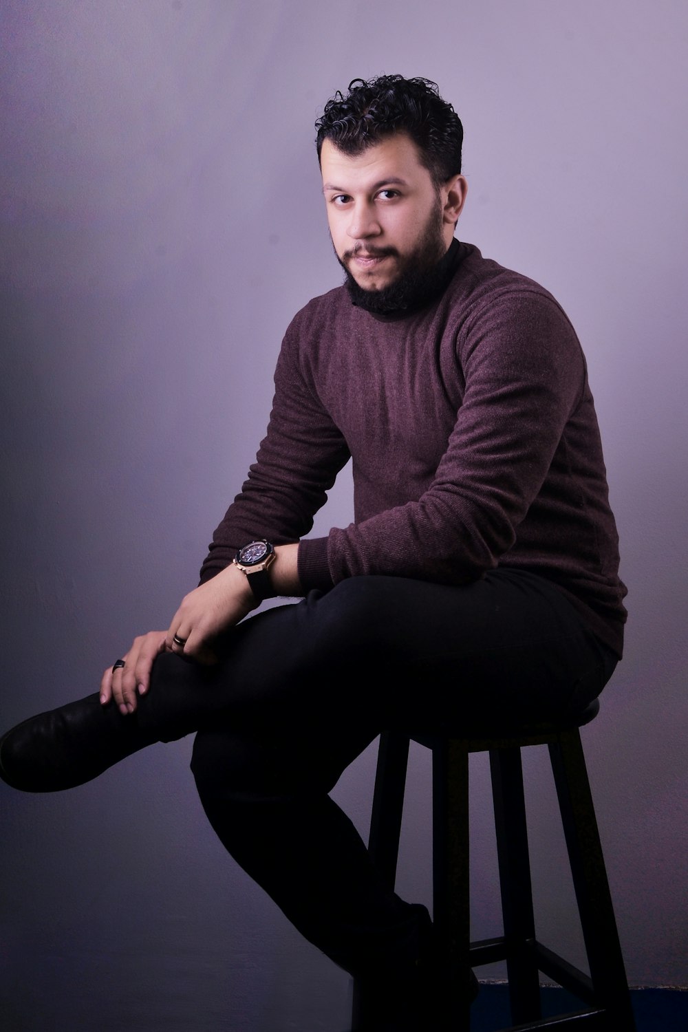 man in brown sweater and black pants sitting on black seat