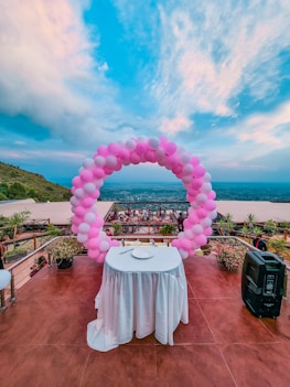 pink and blue balloons on top of white round table