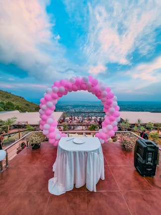 pink and blue balloons on top of white round table