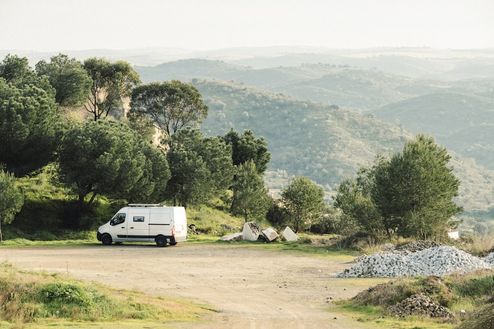 white van on road near green trees during daytime