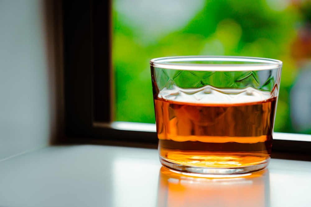 clear drinking glass with brown liquid