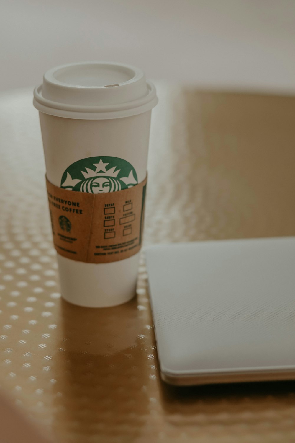 white starbucks disposable cup on white table