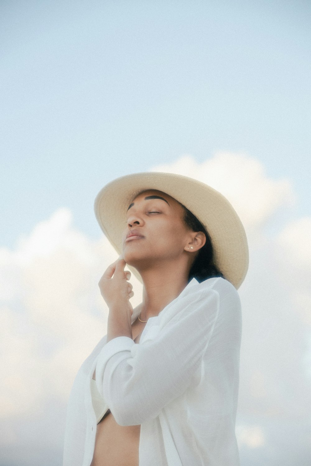 woman in white long sleeve shirt wearing brown hat