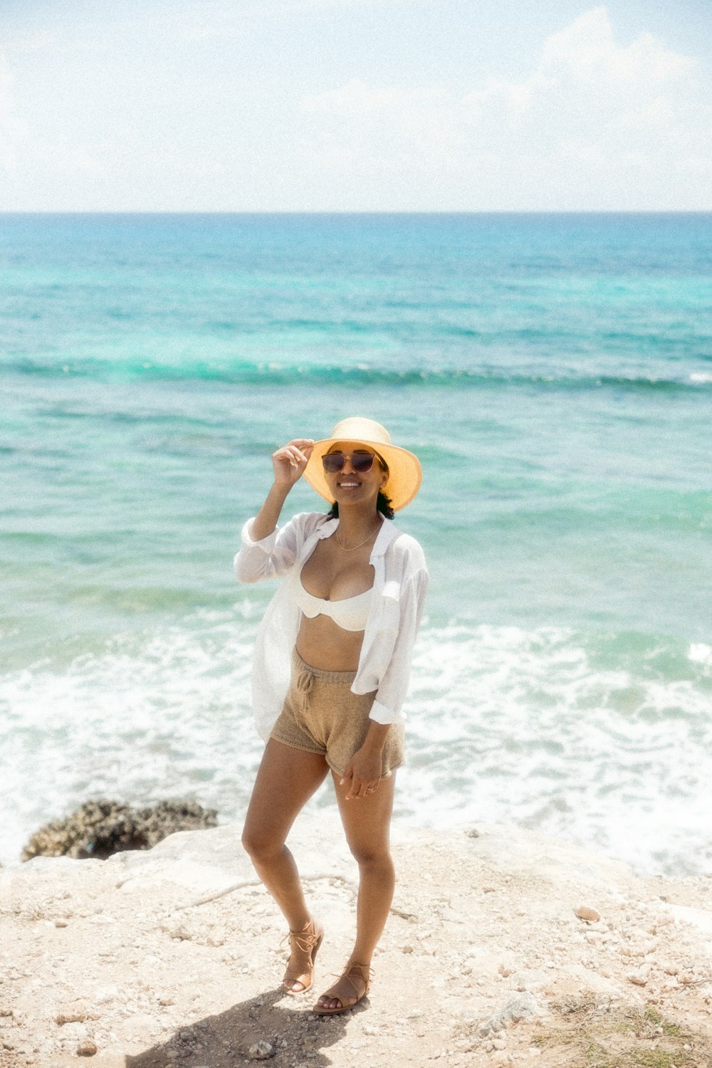 woman in white bikini standing on beach during daytime