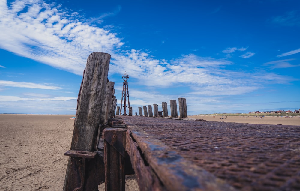 brown wooden fence on brown sand during daytime