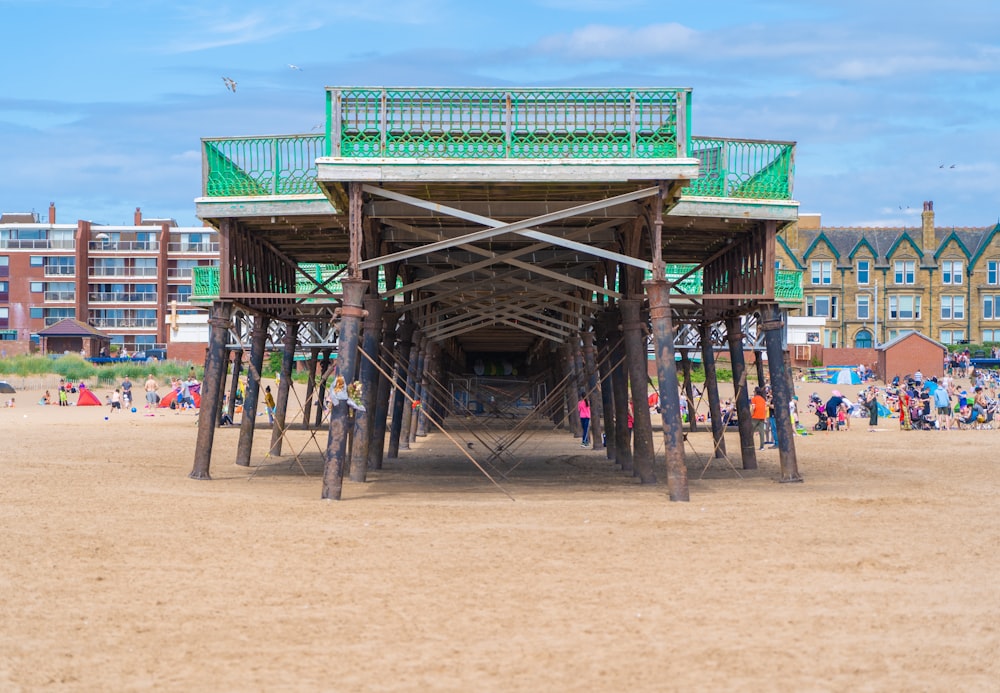 brown wooden beach dock on brown sand during daytime