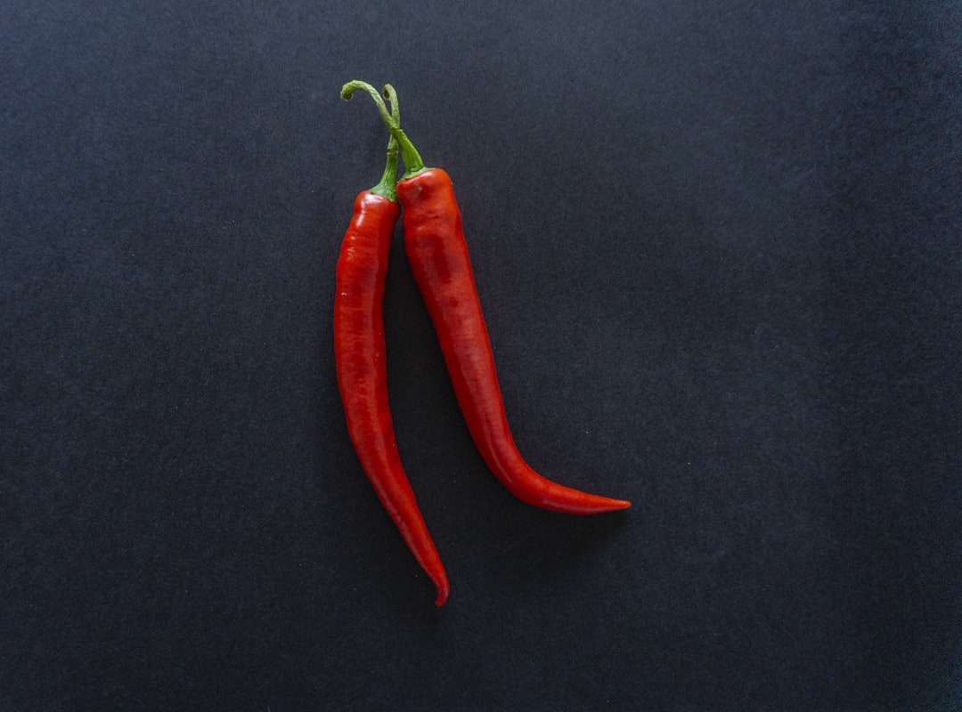 red chili pepper on black surface, Chili peppers on a black background