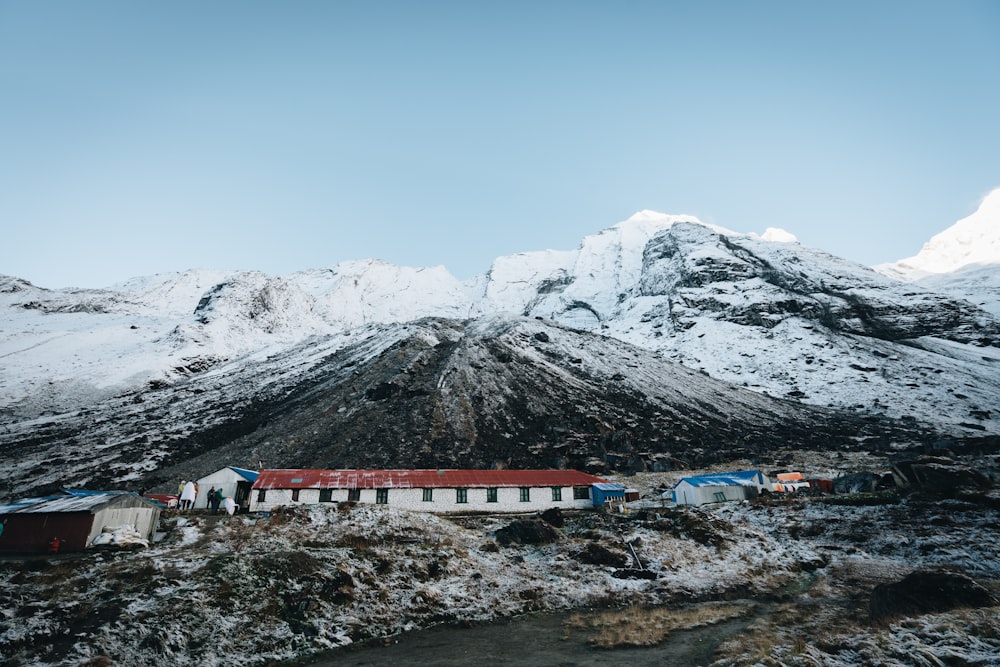 ein schneebedeckter Berg mit einem kleinen Dorf im Vordergrund