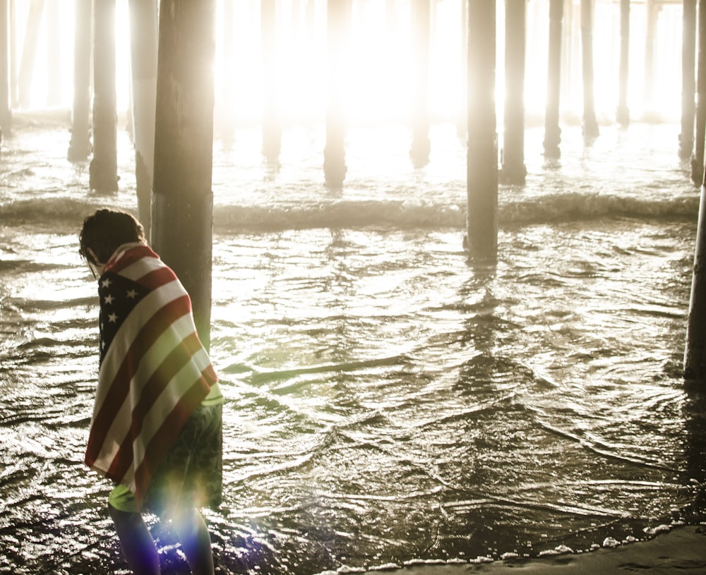 person in black white and green striped hoodie on water