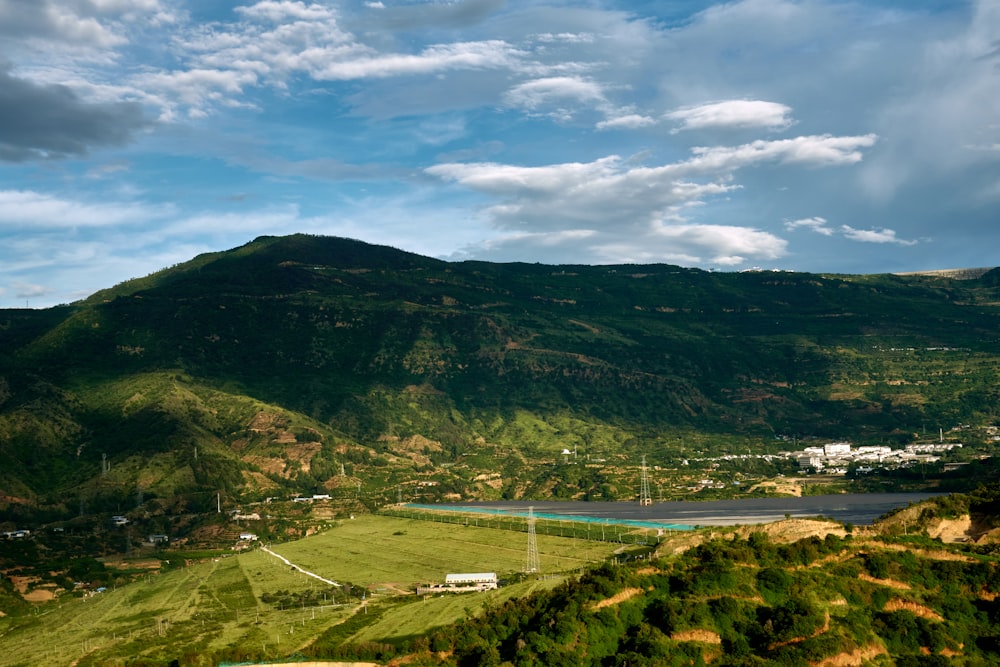 green and brown mountains under white clouds and blue sky during daytime