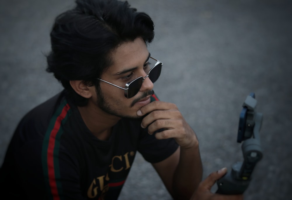man in black and red crew neck t-shirt wearing black framed eyeglasses