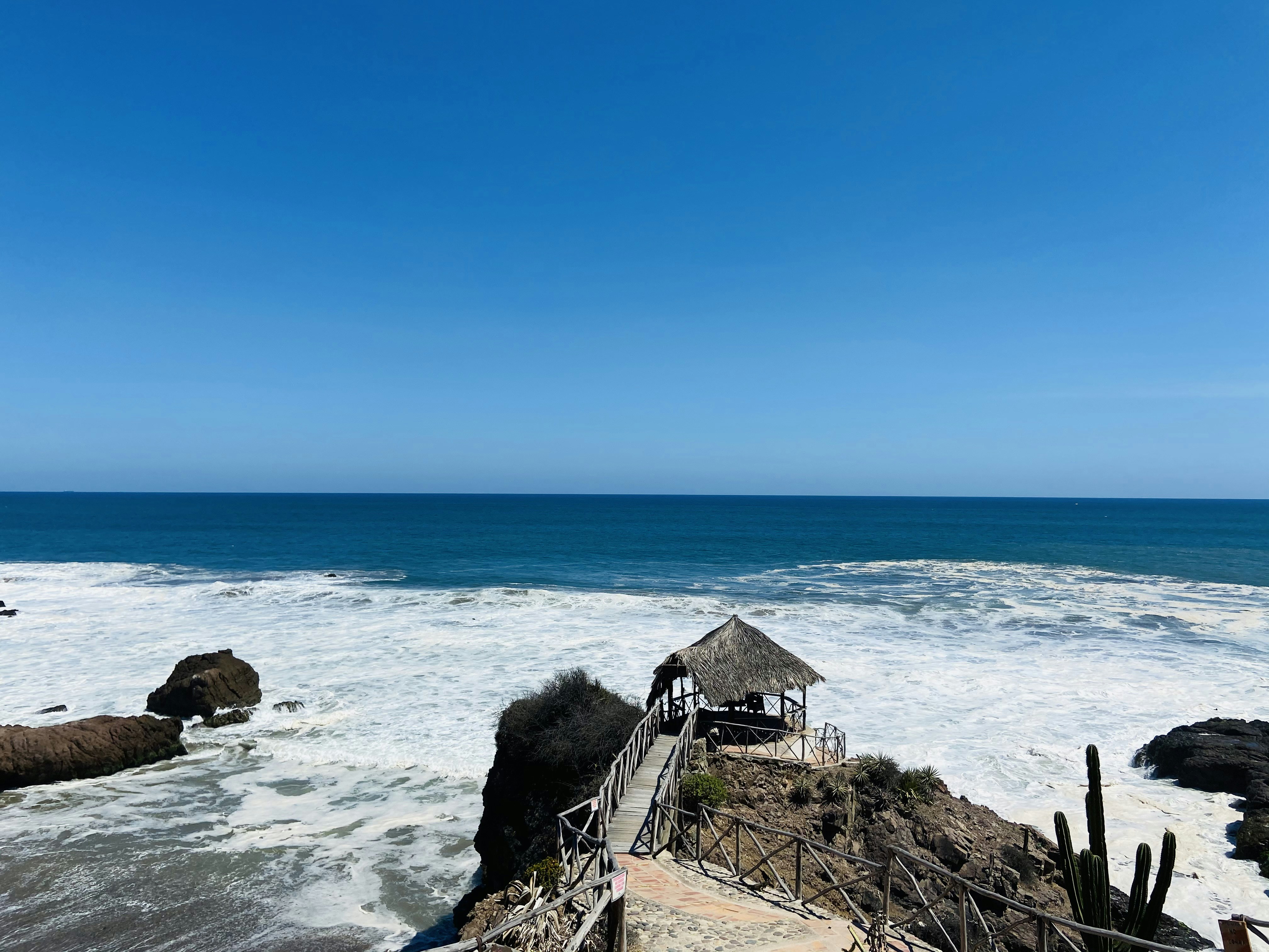 brown wooden house on brown rock formation near body of water during daytime