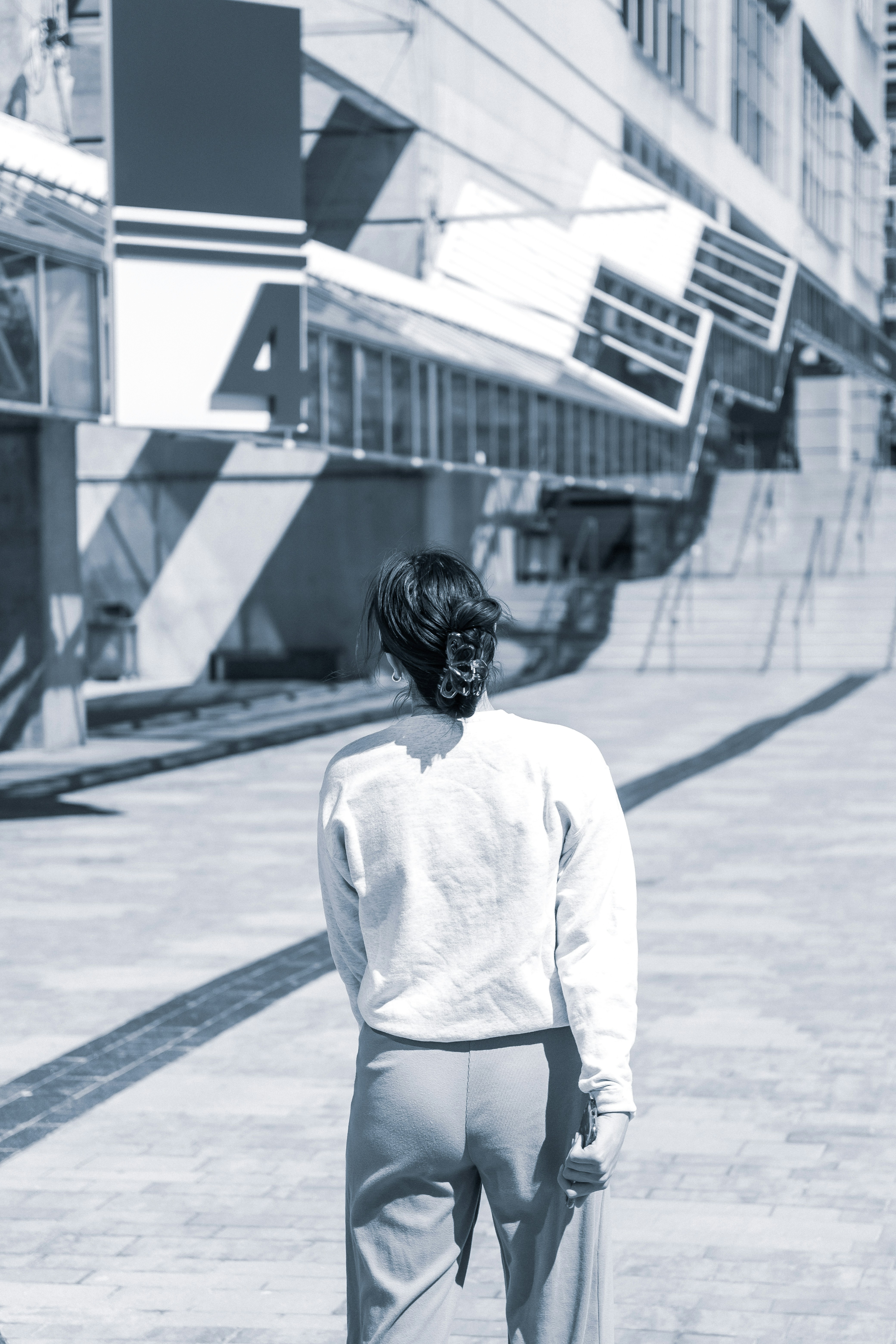 woman in white long sleeve shirt standing on sidewalk during daytime