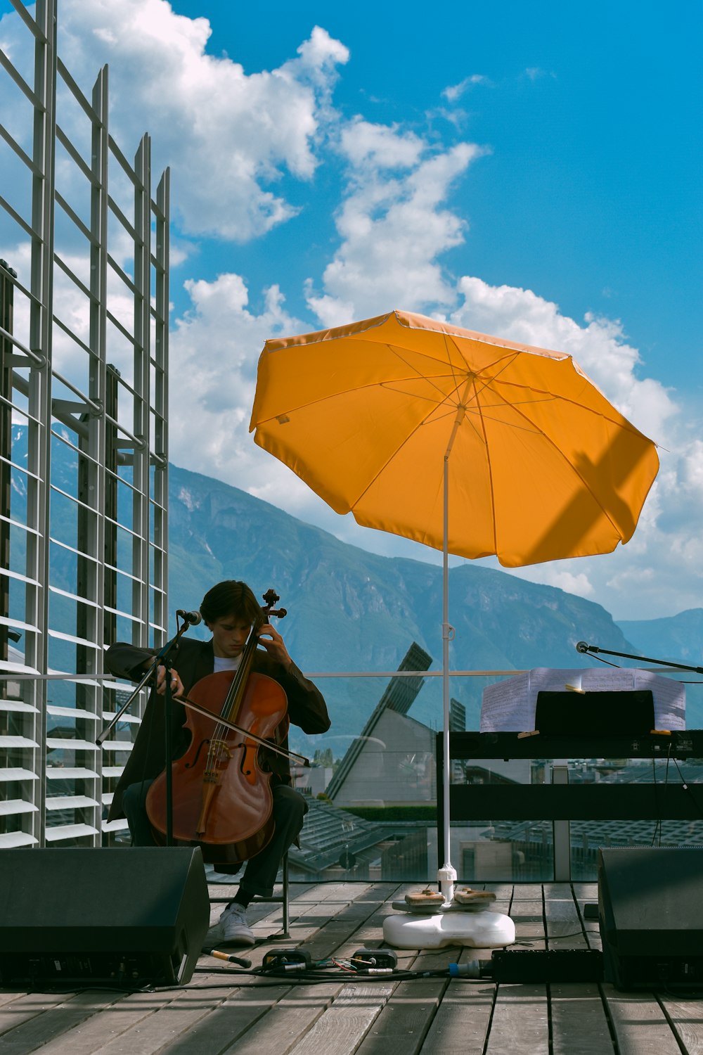 man in black t-shirt and black pants holding orange umbrella