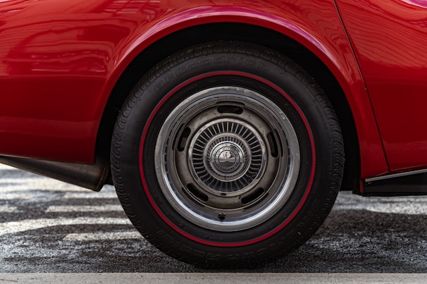Close-up of a wheelchair wheel featuring a vibrant, custom hub cap with a fiery red and orange flame design.