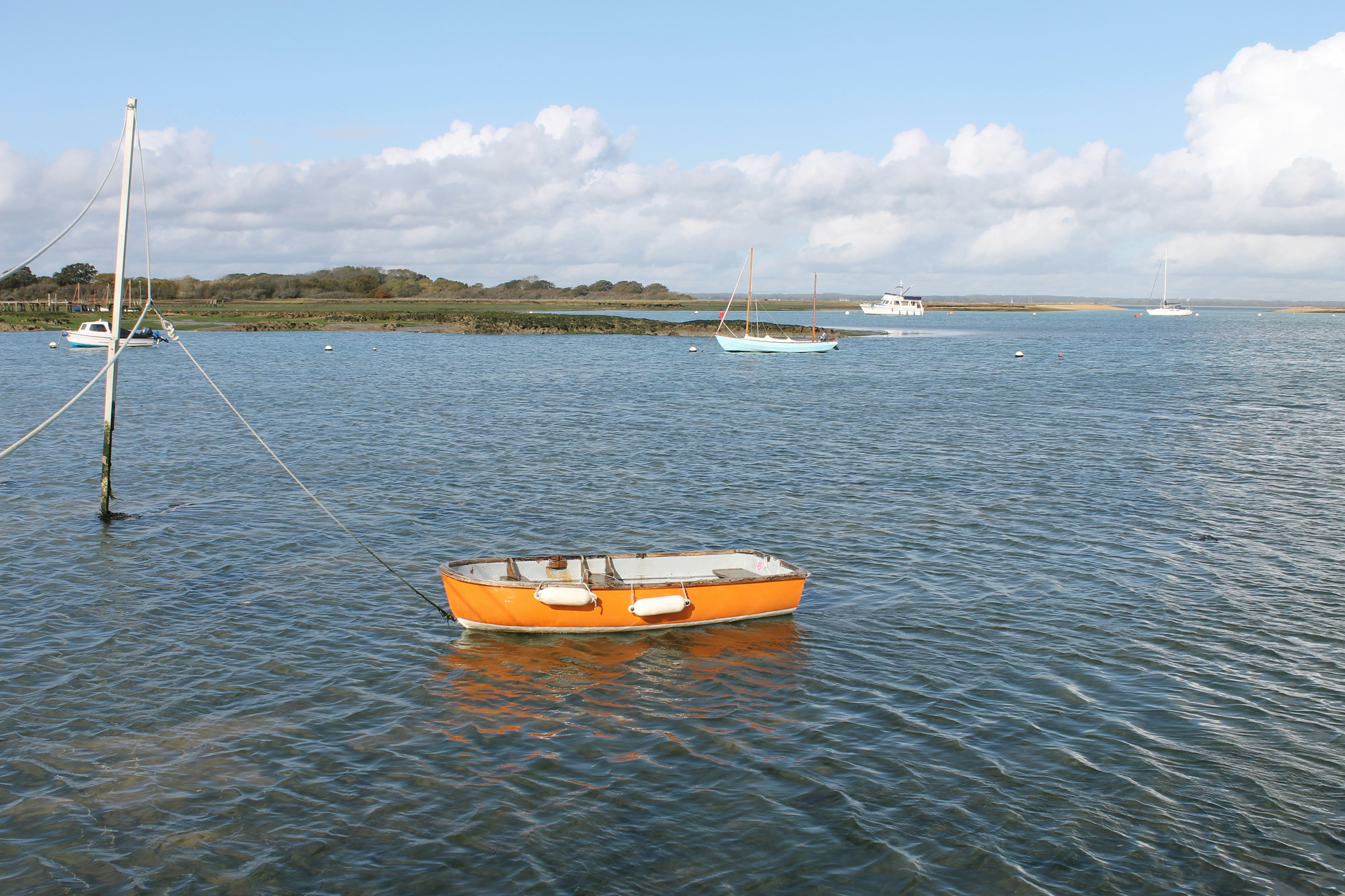 orange and white boat on sea during daytime