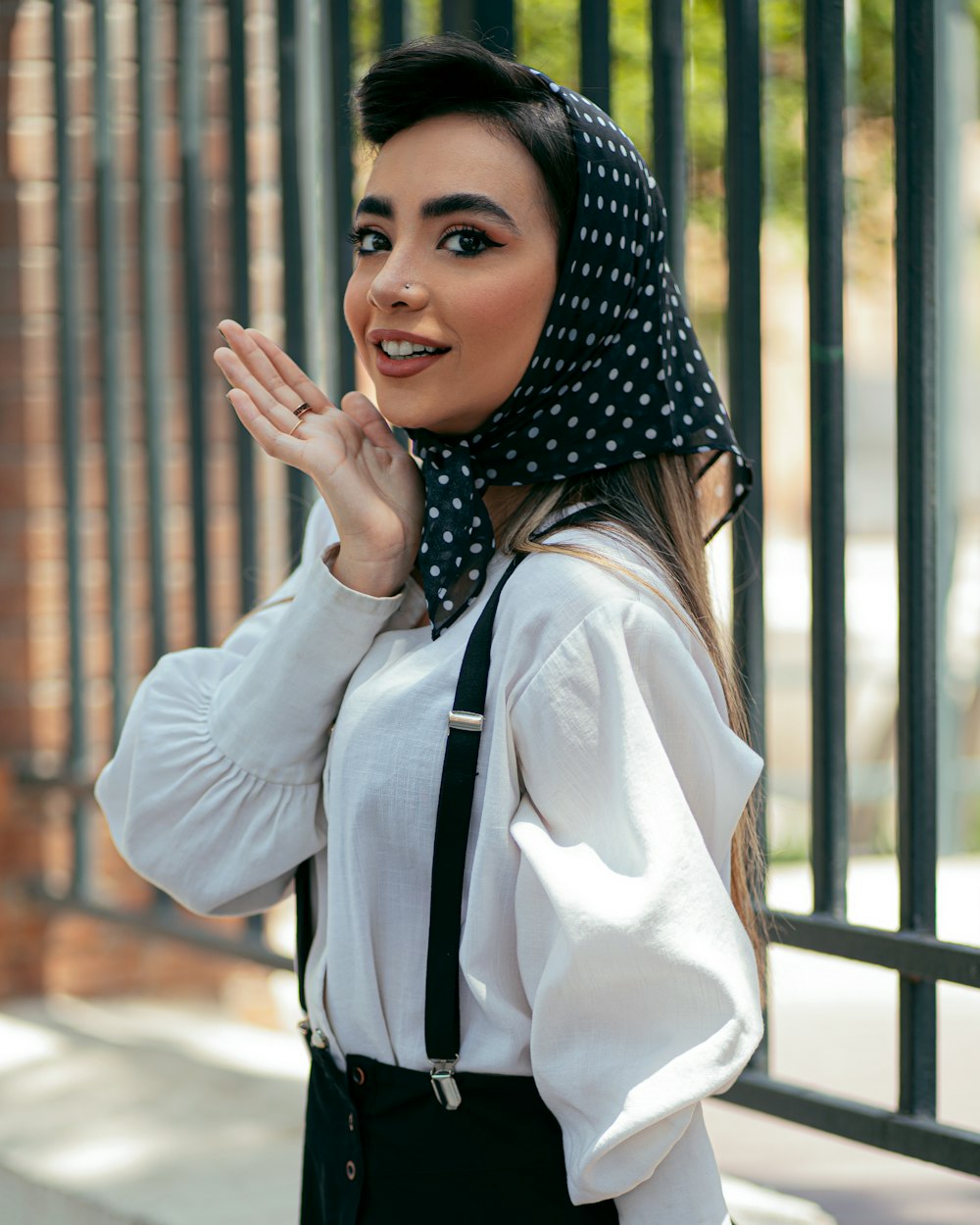 donna in camicia bianca a maniche lunghe e hijab a pois bianco e nero
