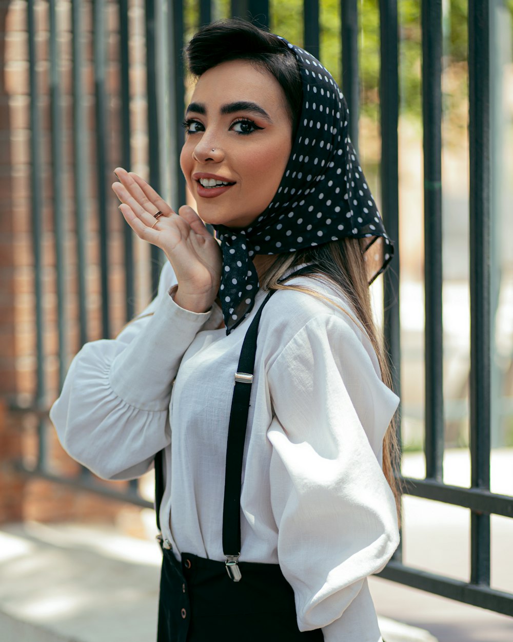 Femme en chemise blanche à manches longues et hijab à pois noir et blanc