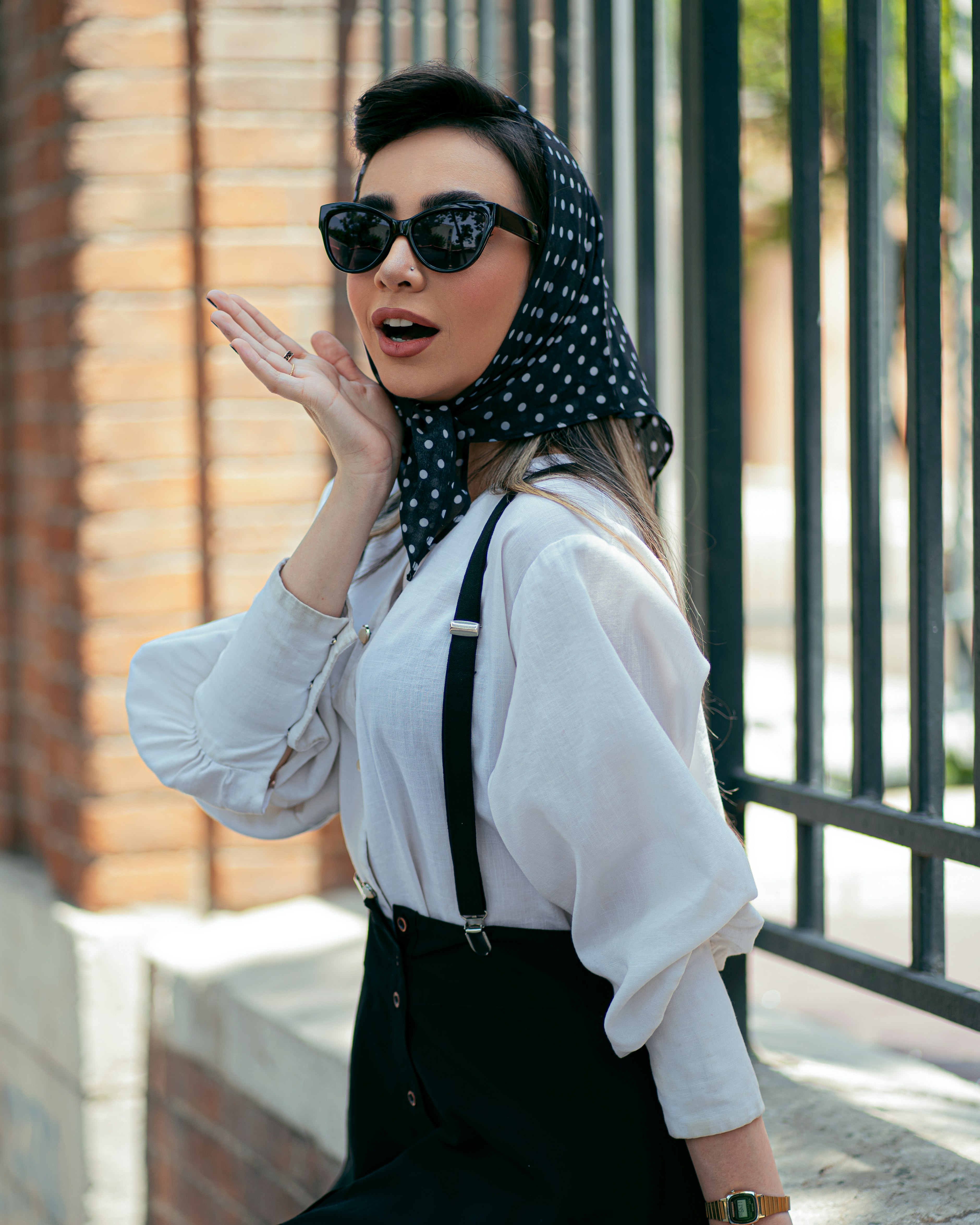 woman in white long sleeve shirt and black pants wearing black sunglasses