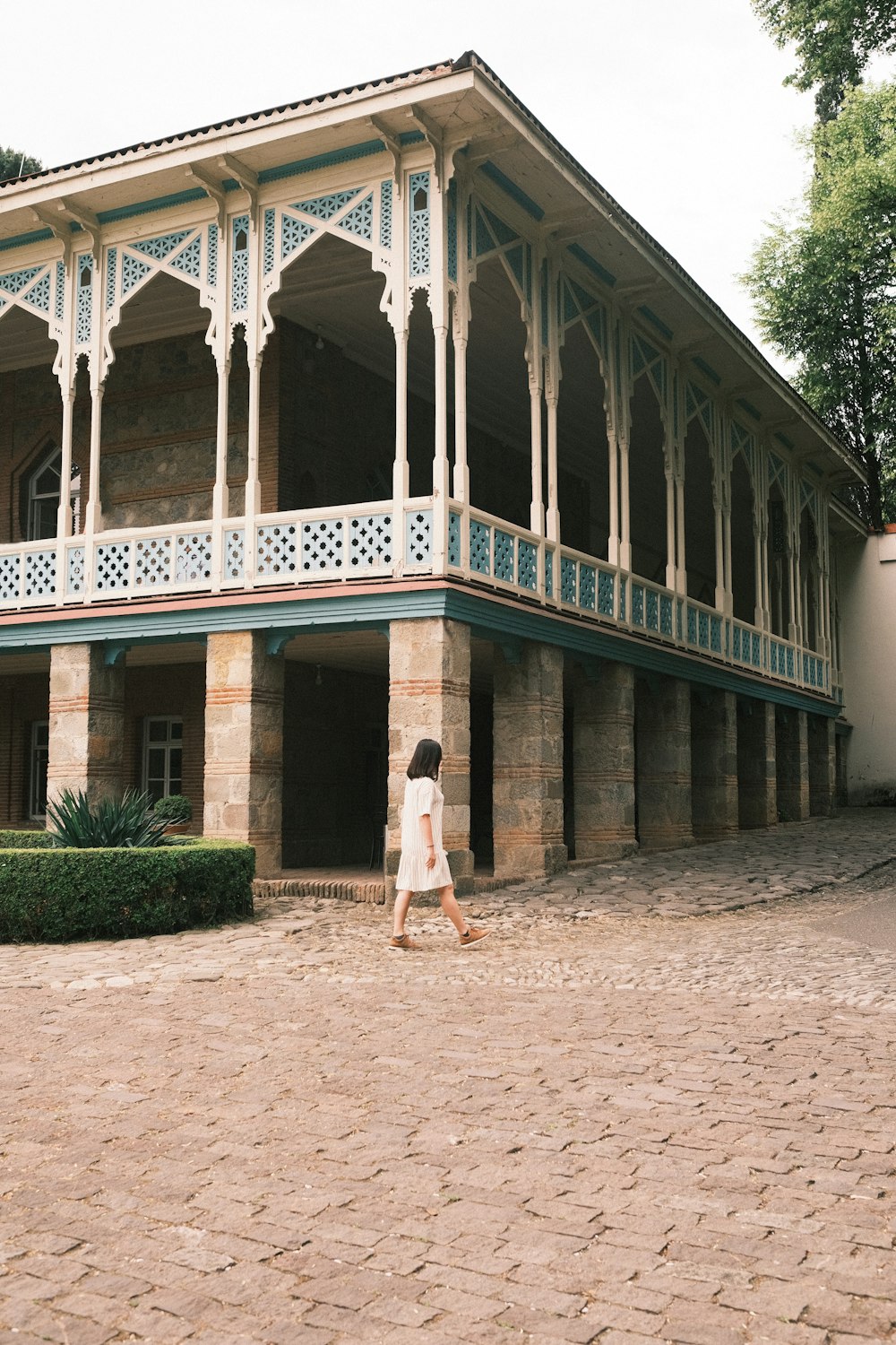 woman in white dress standing on brown concrete floor during daytime