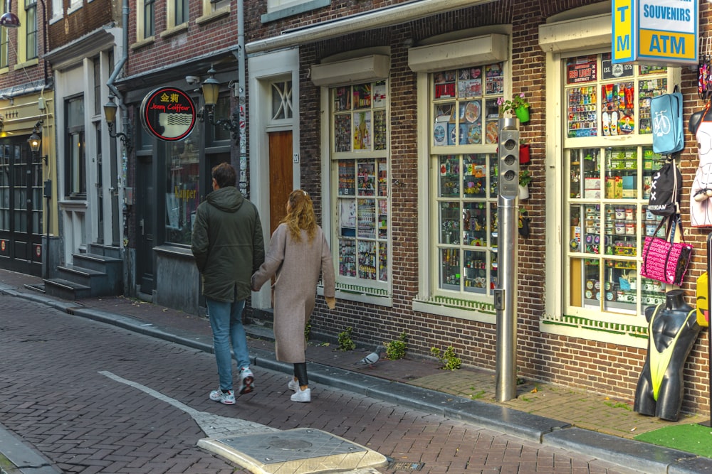 woman in brown coat walking on sidewalk during daytime