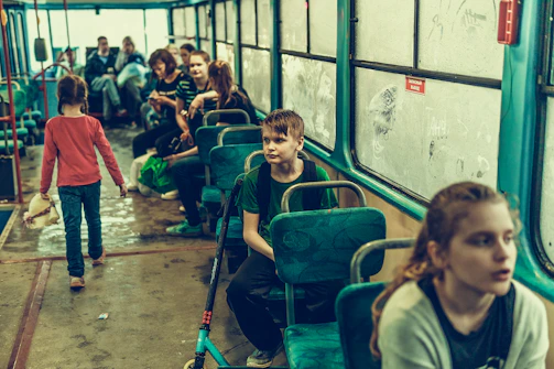 A group of kids chatting happily while seated inside the Rotabrilho school bus.