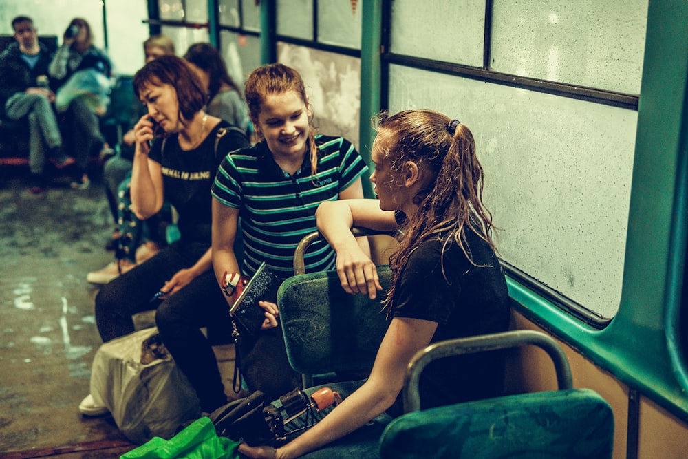 a group of people sitting on a train next to each other