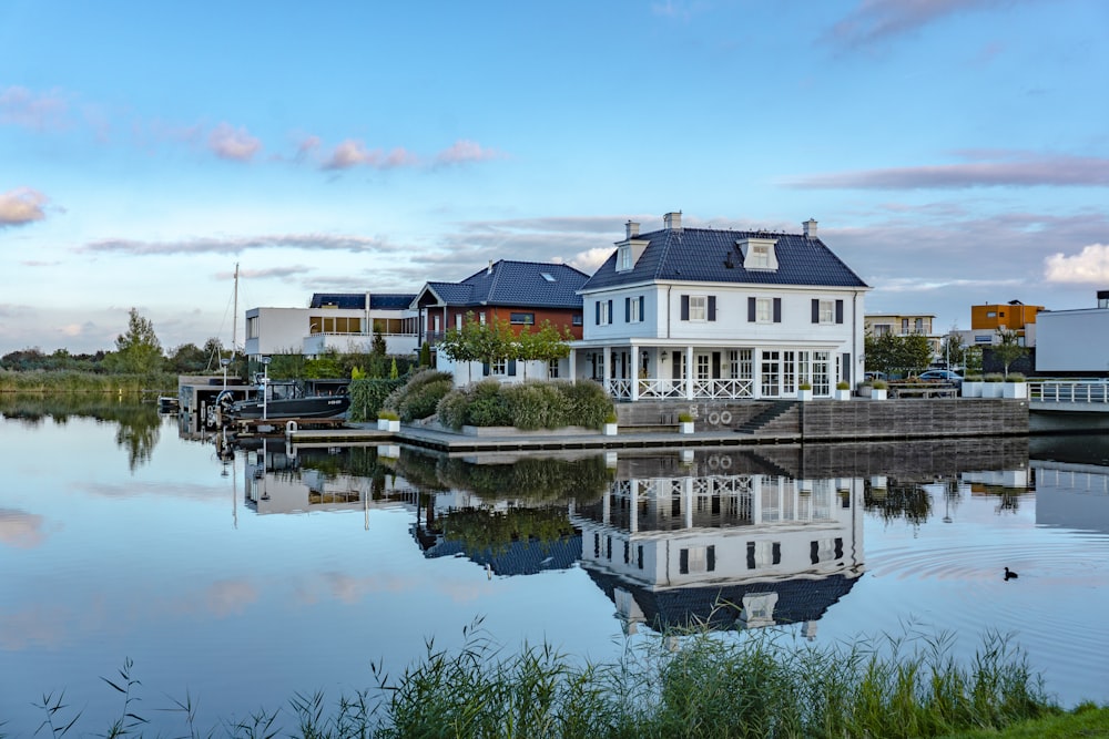 Bâtiment en béton blanc et brun à côté d’un plan d’eau pendant la journée