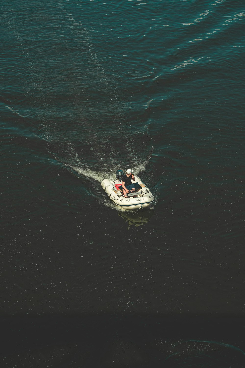 man in white and black power boat on blue sea water during daytime