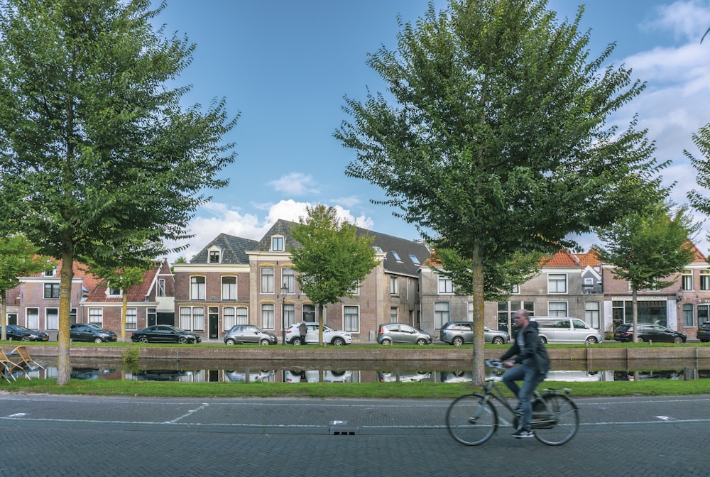 man in black shirt riding bicycle on road during daytime