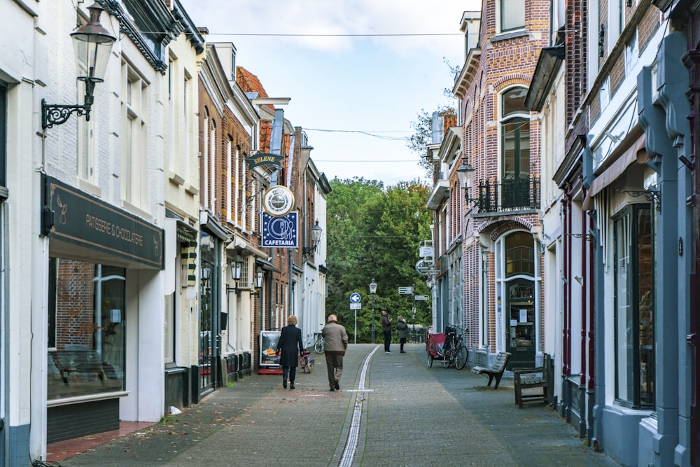 people walking on sidewalk near buildings during daytime