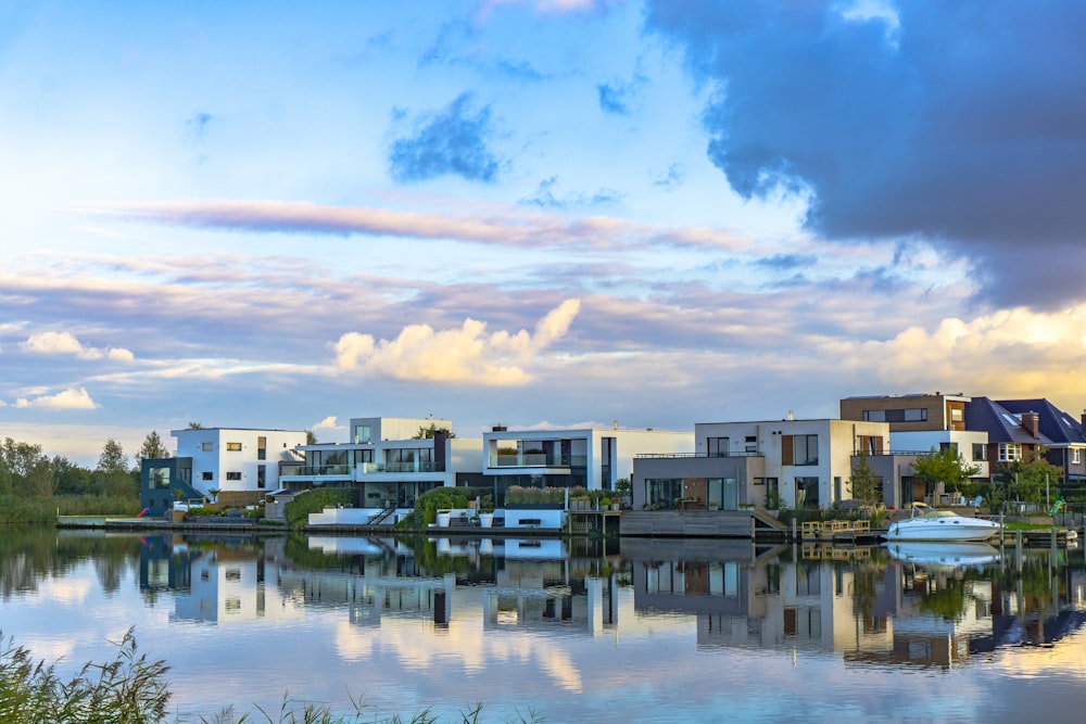 white and brown concrete buildings near body of water under blue and white cloudy sky during