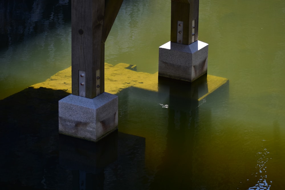 a couple of concrete pillars sitting in the middle of a body of water