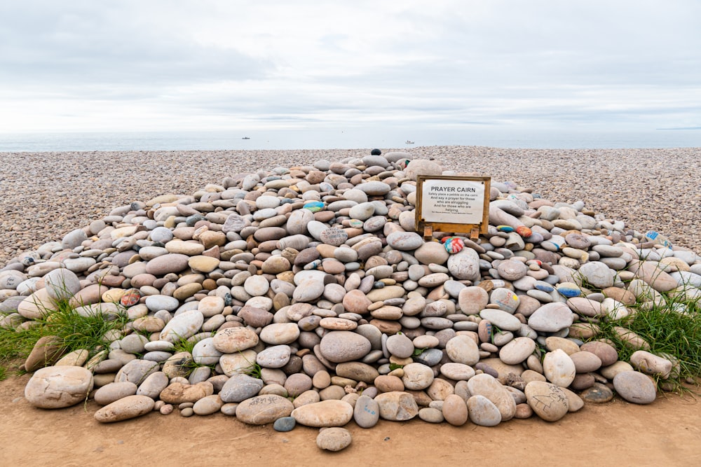 a pile of rocks sitting on top of a sandy beach