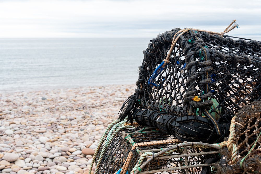 a pile of fishing nets sitting on top of a rocky beach