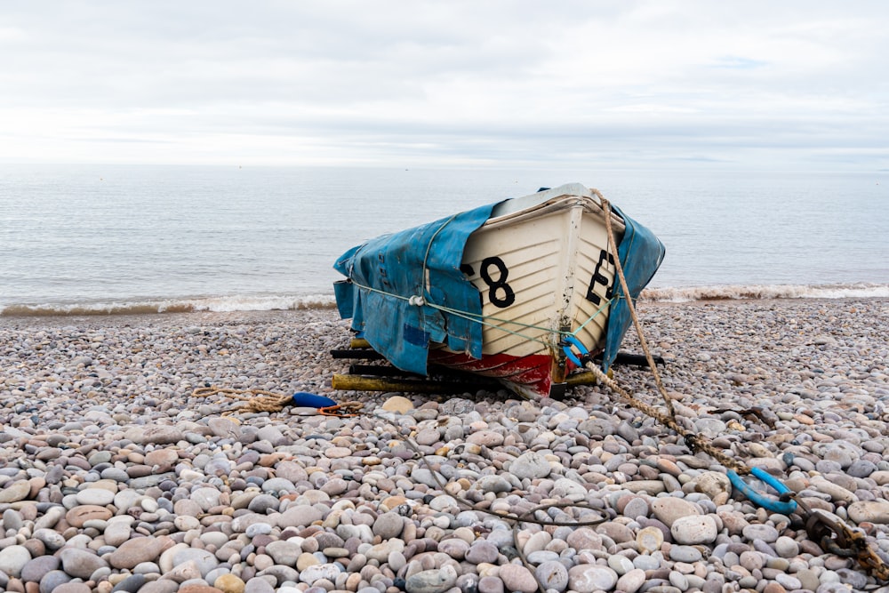 a boat sitting on top of a rocky beach