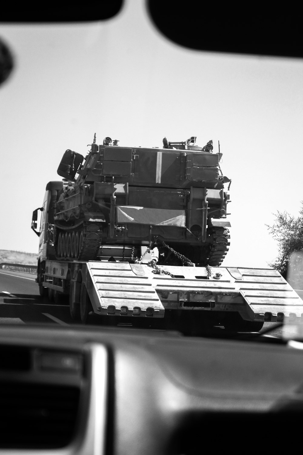 a large military vehicle driving down a highway