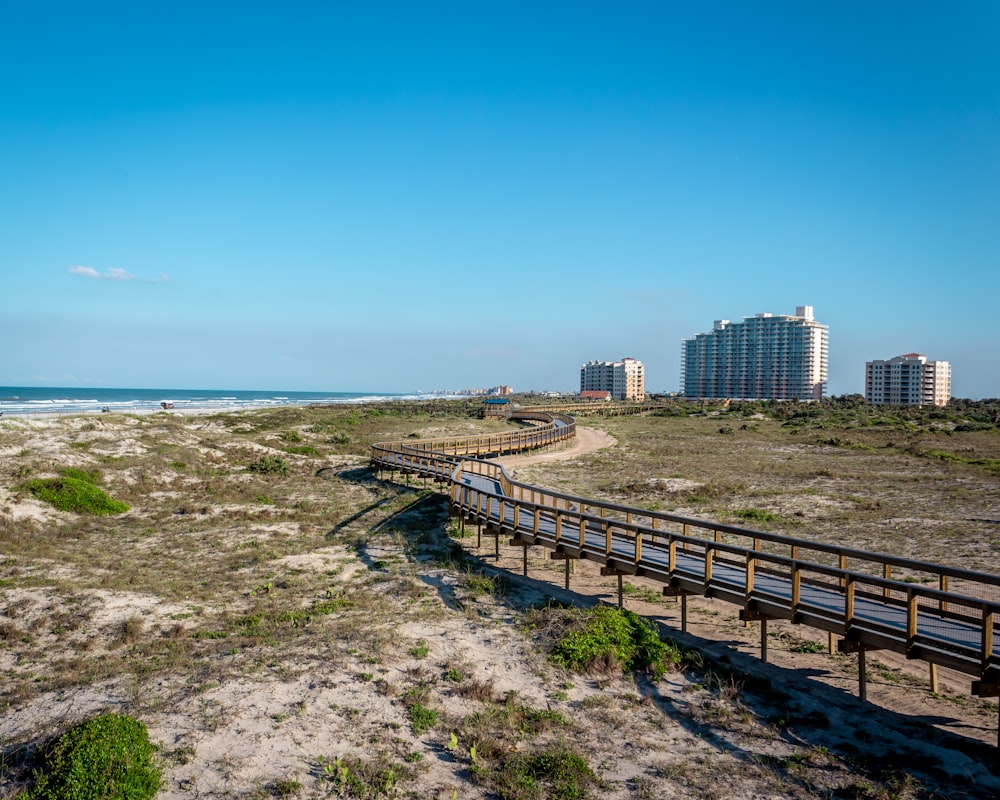 a long wooden bridge over a sandy beach