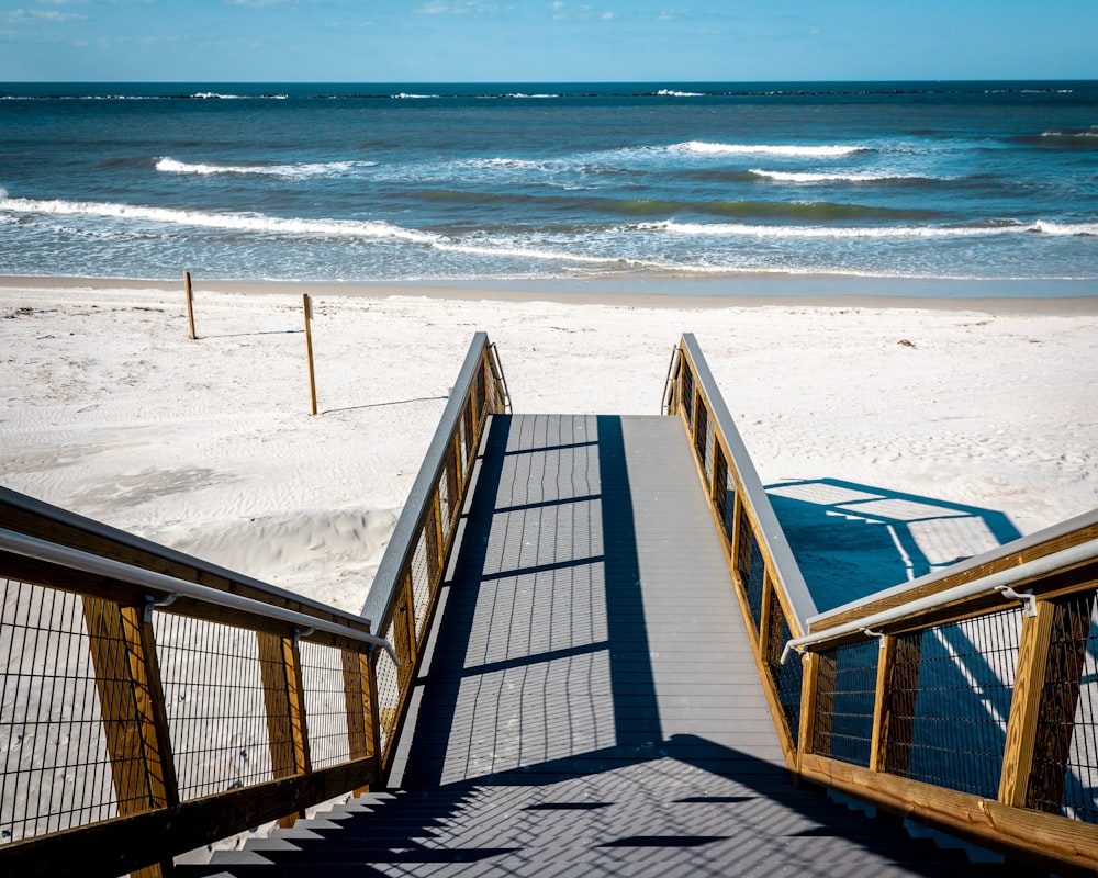 eine Treppe, die hinunter zum Strand führt, mit dem Meer im Hintergrund