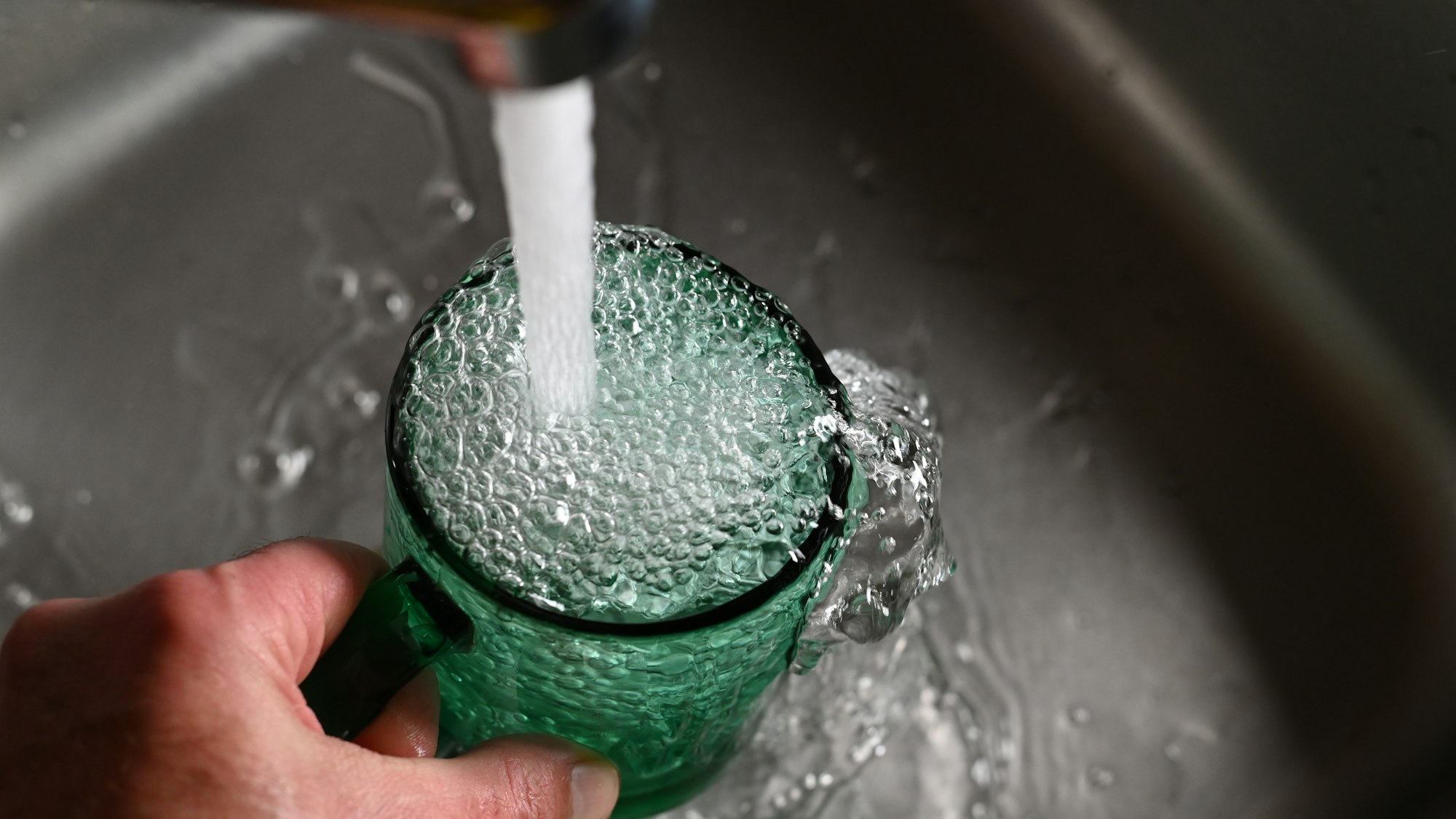 Tap water flows into the cup