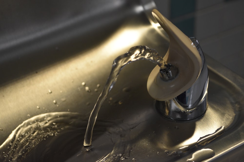 a close up of a sink with a faucet running