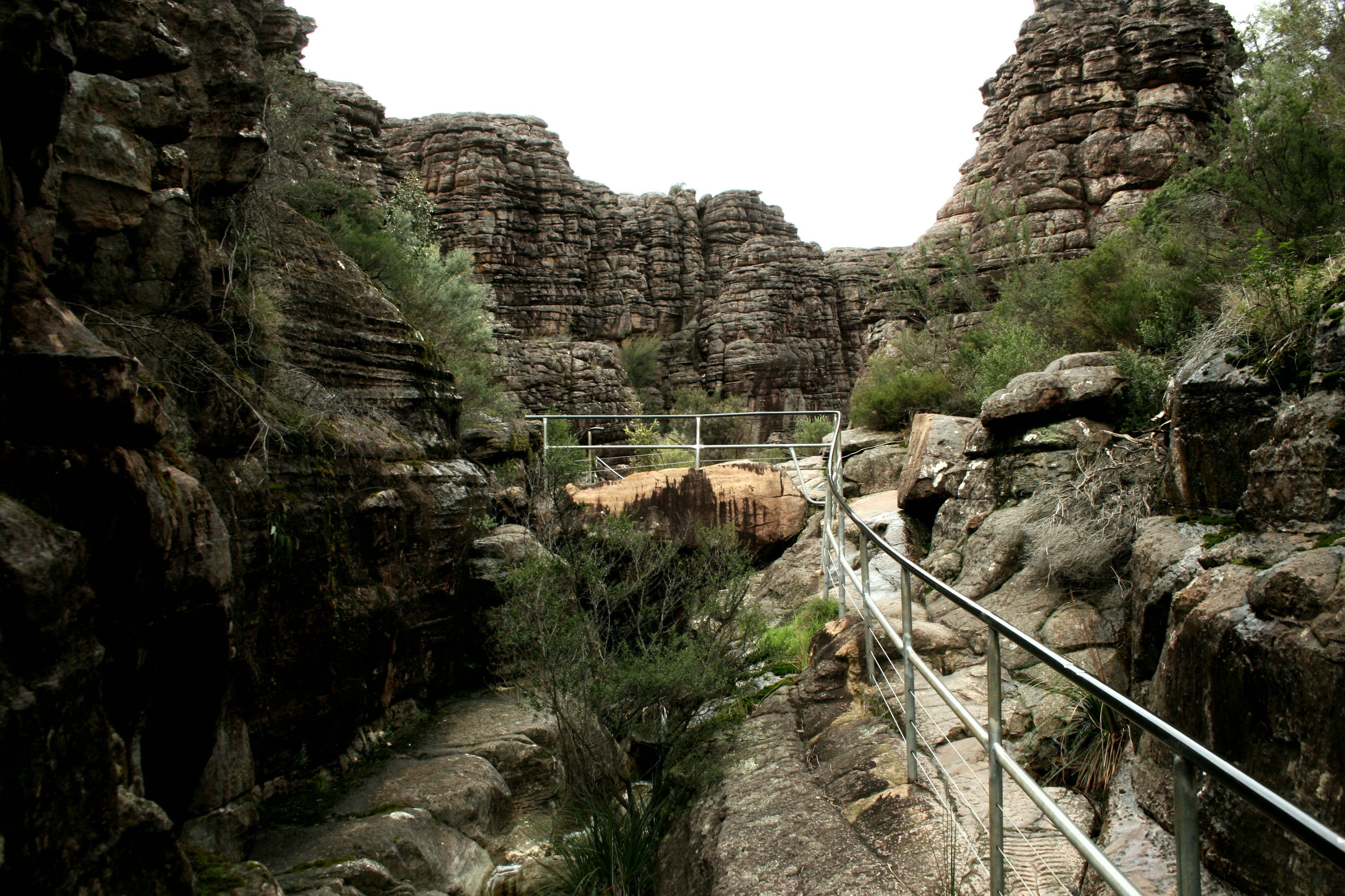 a metal walkway going through a rocky canyon