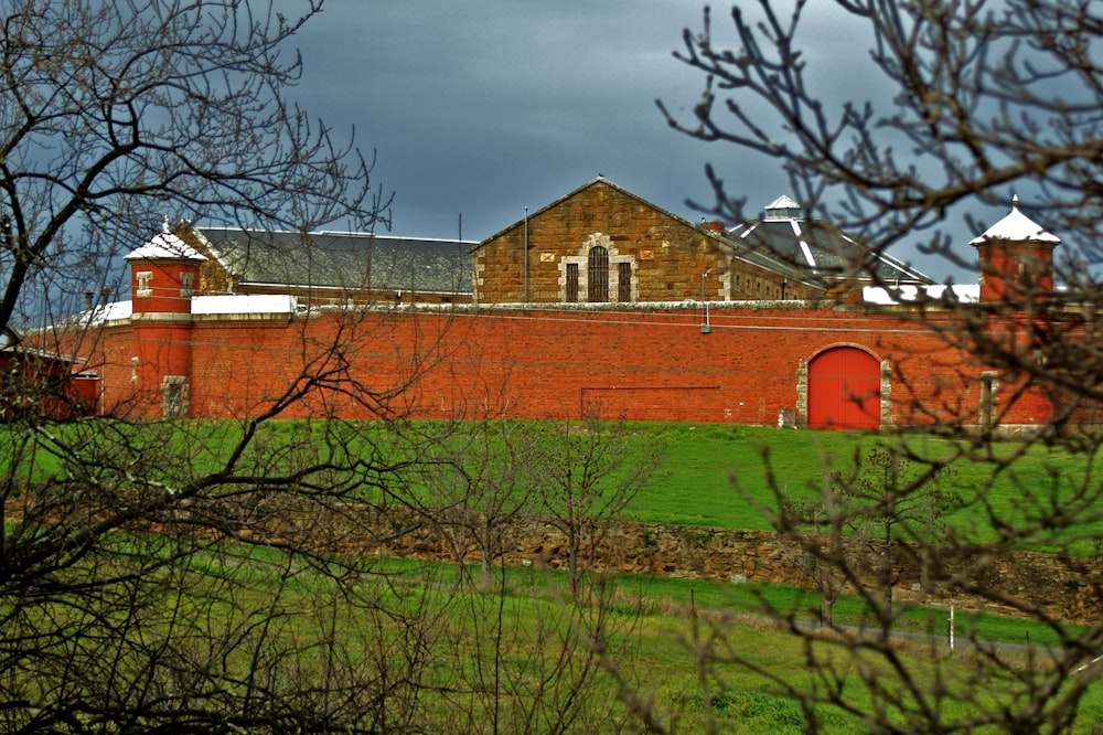 brown concrete building near bare trees under cloudy sky during daytime