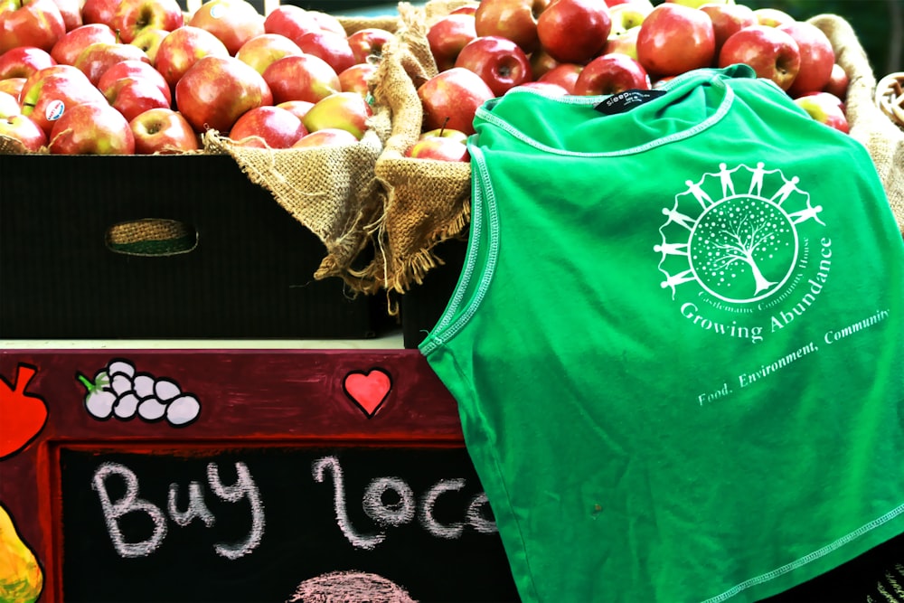 green crew neck shirt near apple fruits