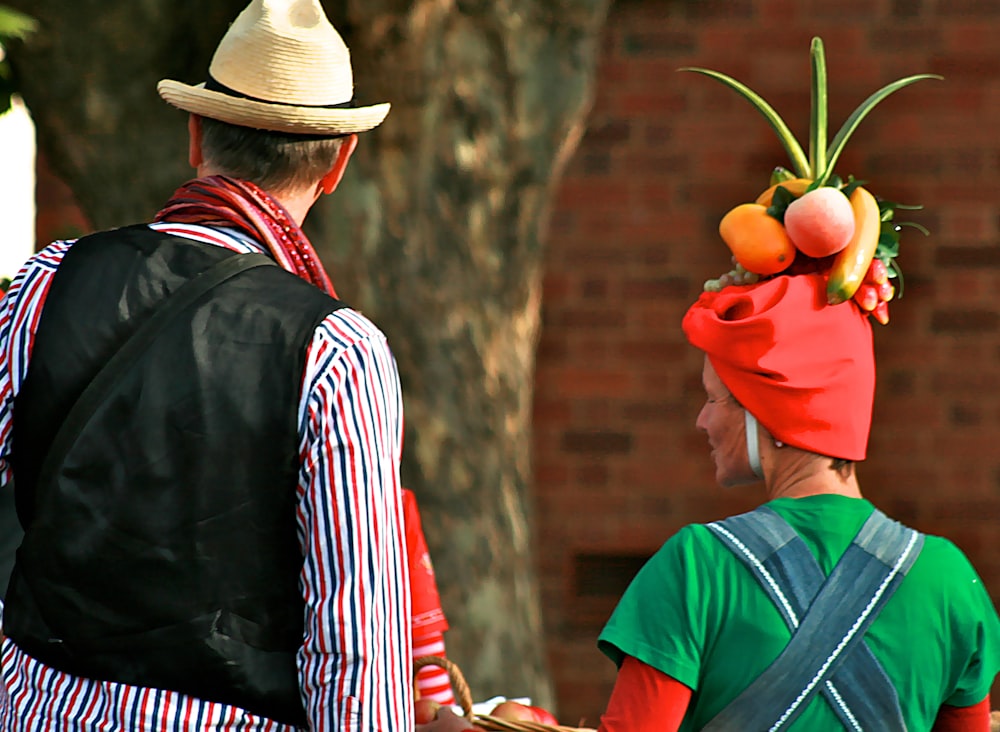 man in red hat holding apple fruit