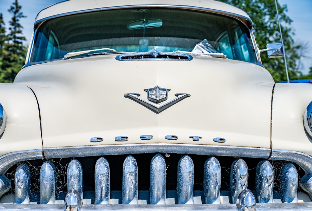 the front of a classic car with chrome grills
